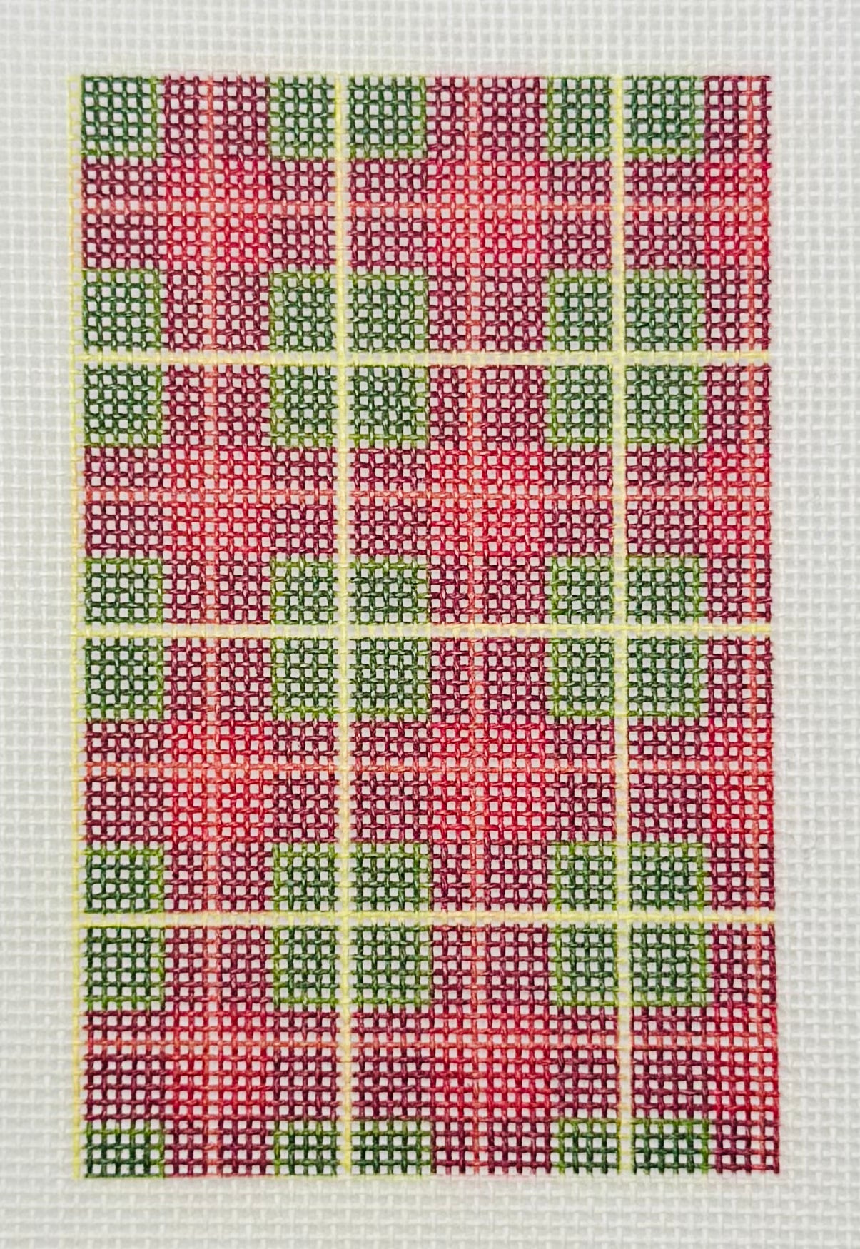 Tilli Tomas Planet Earth needlepoint canvas of design with grid pattern with red, green, and yellow squares
