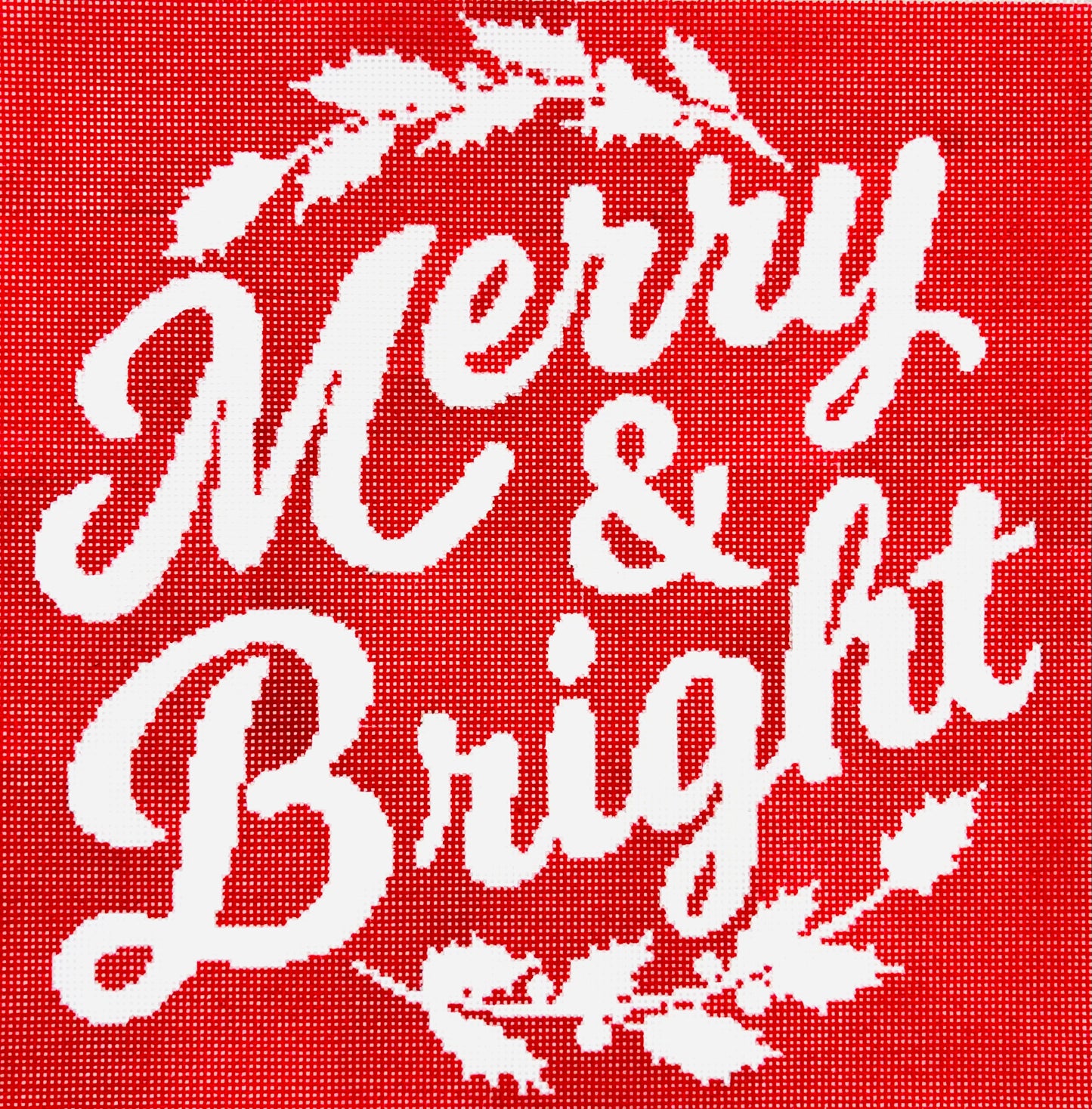 A Stitch in Time needlepoint canvas of white text 'Merry & Bright' on a red background with decorative elements