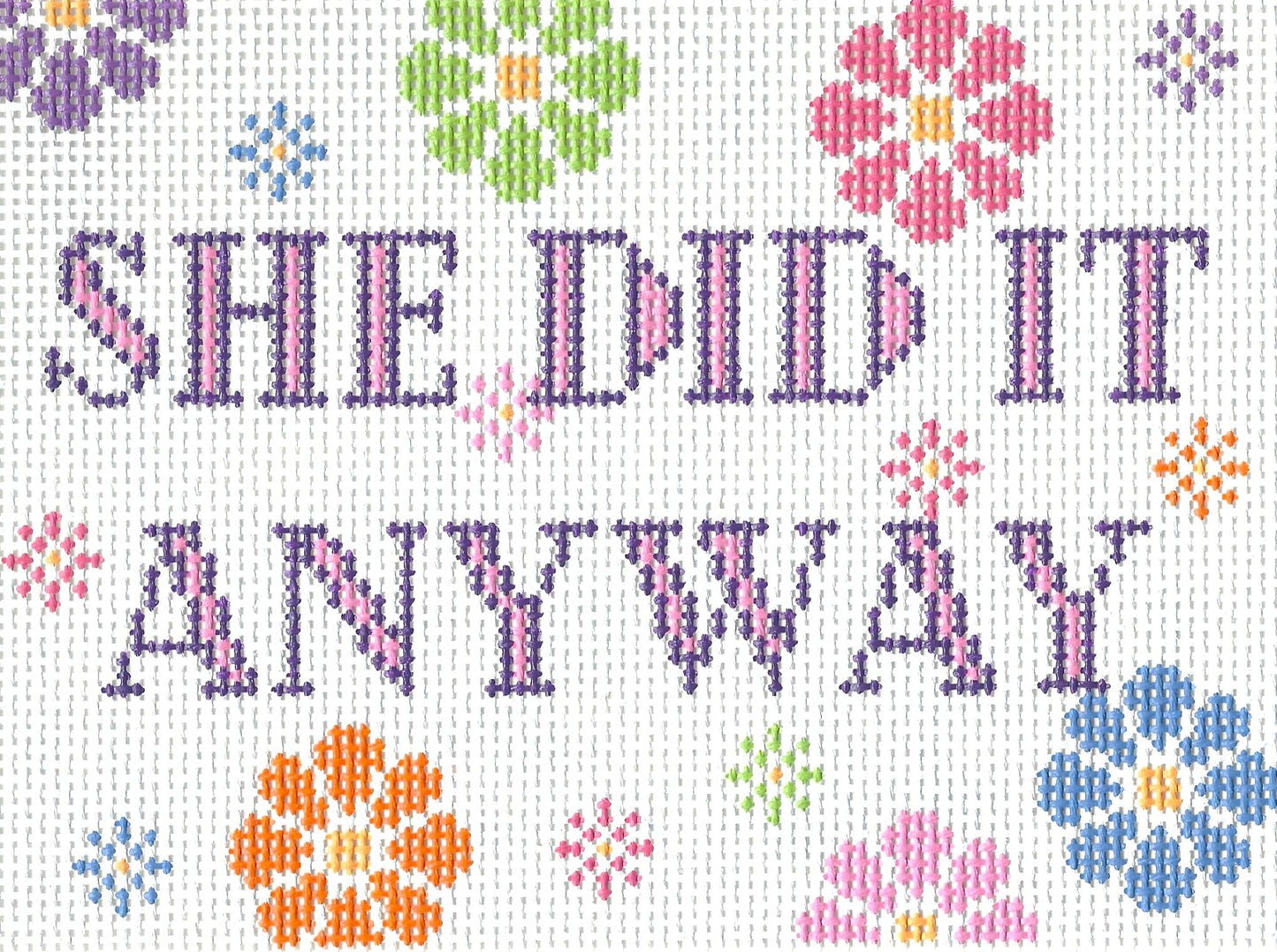 Stitching with Stacey needlepoint canvase of text 'She Did It Anyway' with colorful flowers on a white background