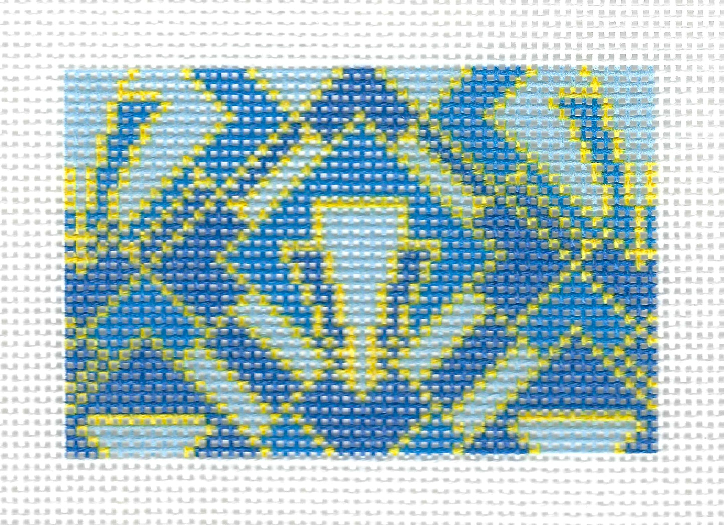 Tilli Tomas Planet Earch square needlepoint canvas featuring a geometric pattern in shades of blue and yellow on a white background.