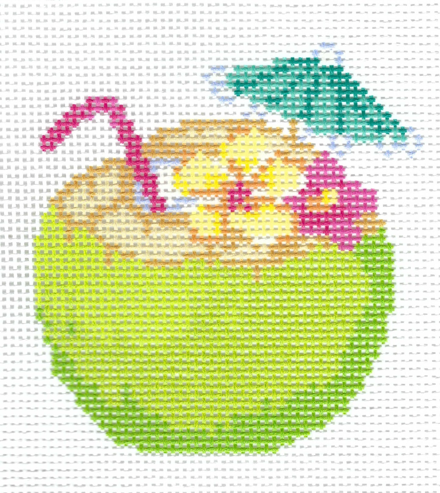 Needlepoint canvas of illustration of a green coconut with a red straw, a green umbrella, and pink and yellow flowers on a white grid background.