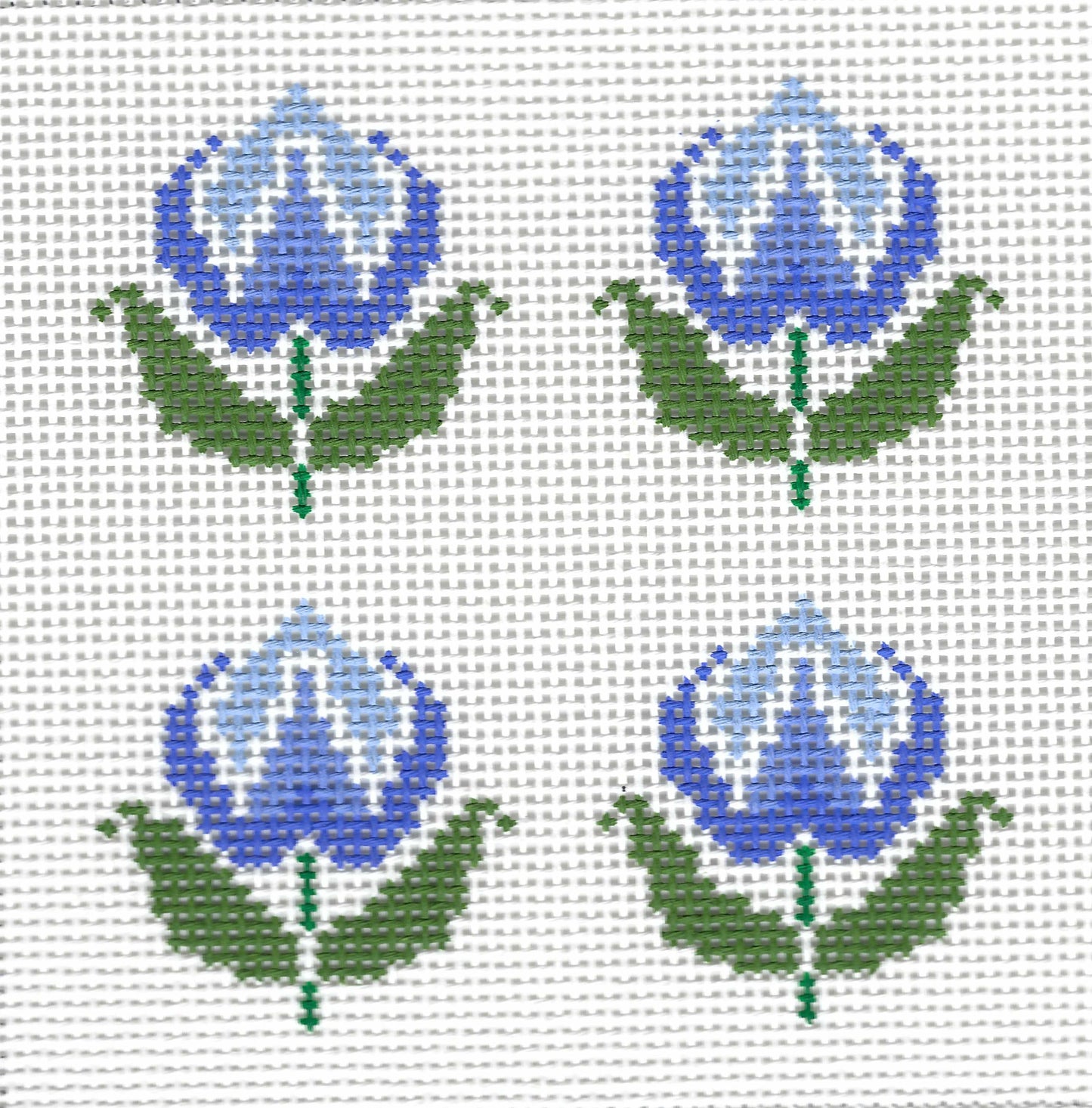 Patricia Stone needlepoint canvas design featuring four blue rose flowers with green leaves arranged in a 2x2 grid on a white background.
