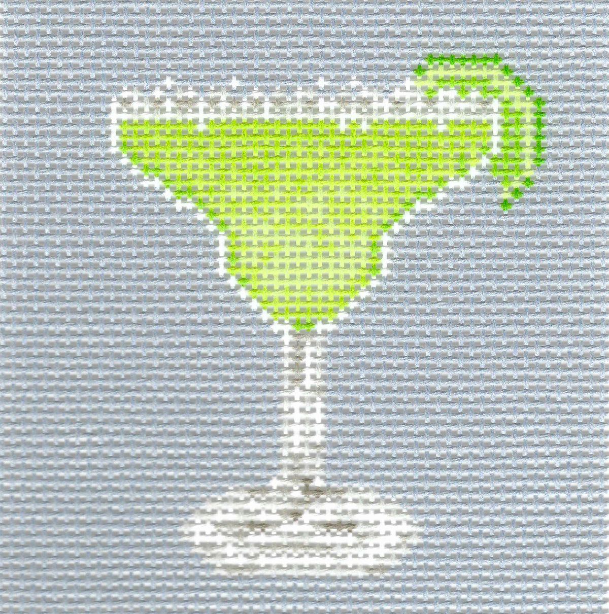 Needlepaint needlepoint canvas of a green cocktail in a margarita glass with a lime wedge, on a light gray background.