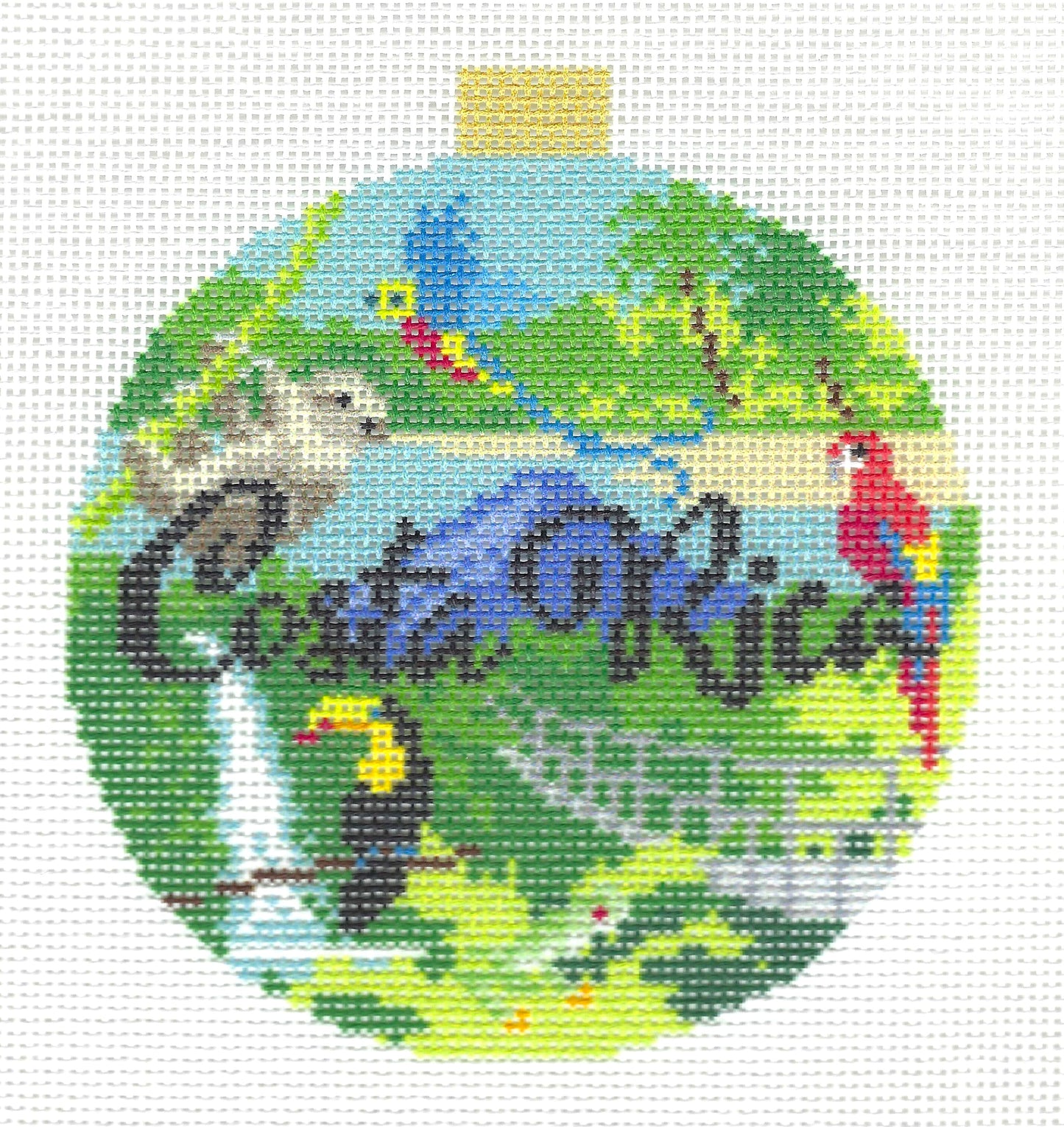 Kirk & Bradley round needlepoint canvas featuring the words 'Costa Rica' in dark script with green foliage, blue water, a red-and-yellow parrot, a toucan, a bird, and a small gold hanging tab at the top.