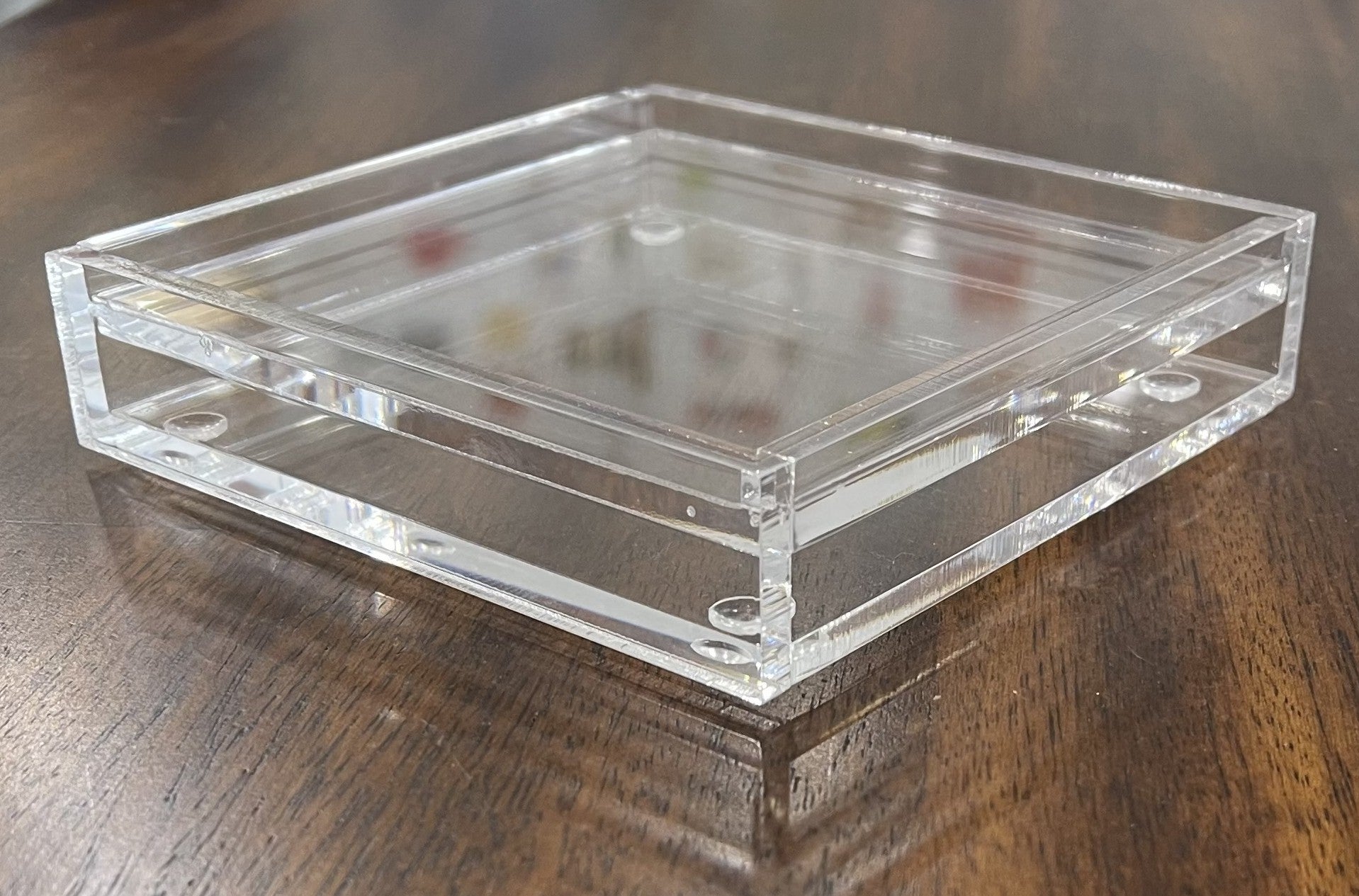 Acrylic 4" coaster on a wooden surface.