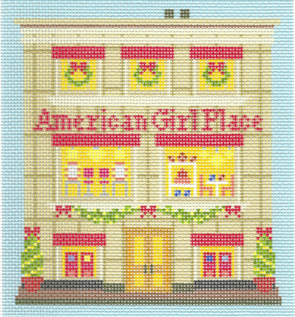 Haus of Toots needlepoint canvas design of a storefront of 'American Girl Place' with three windows showing green wreaths, colorful display windows, a central yellow door, and potted Christmas trees on either side, set against a light blue background.