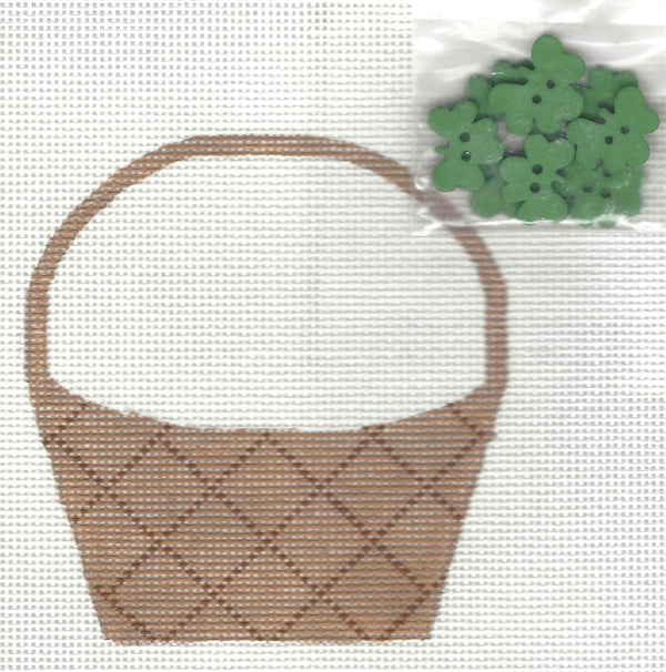Danji Designs needlepoint canvas of a brown basket with green four leaf clovers on a white background.