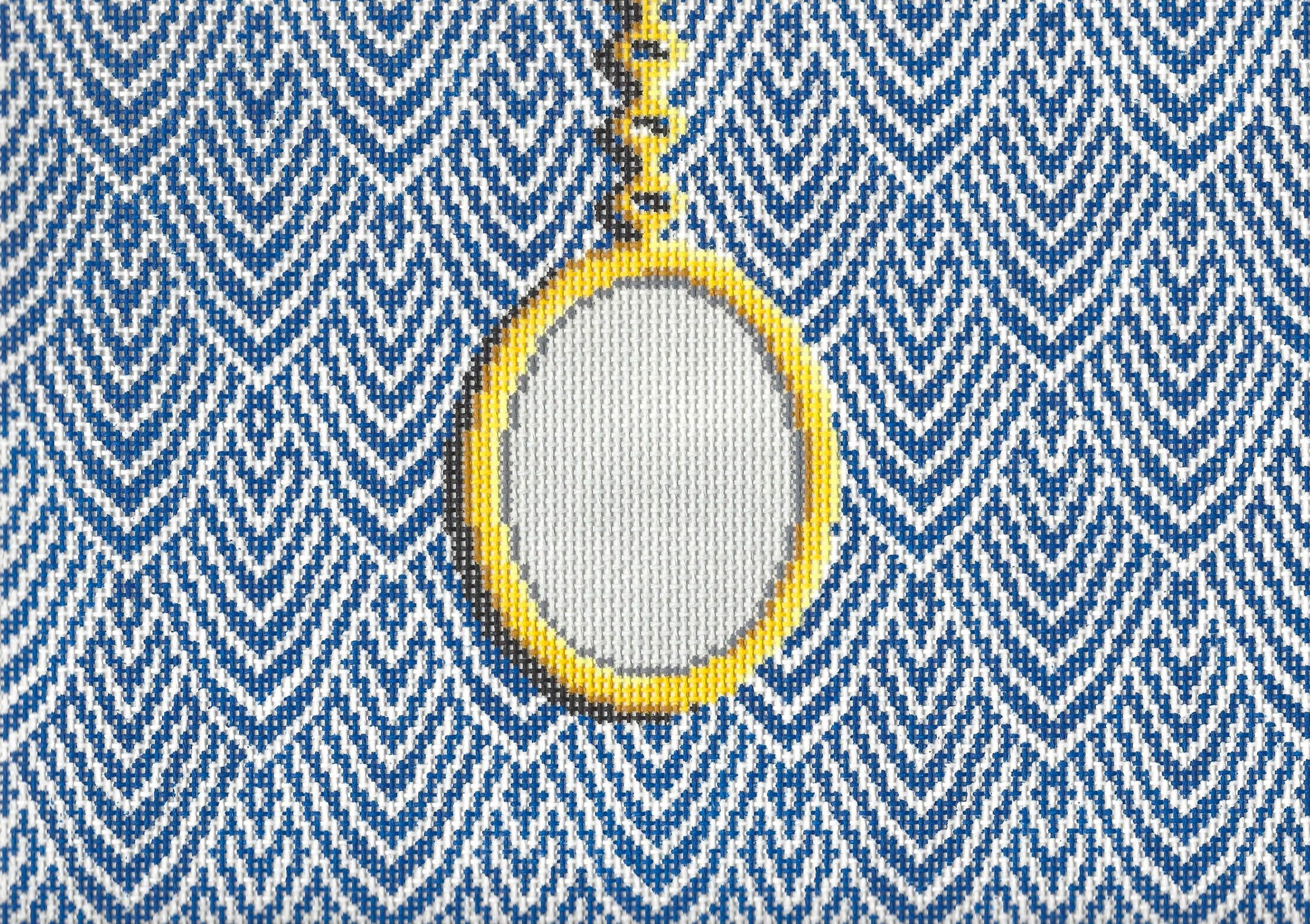 Jeni Sandberg needlepoint canvas of clutch with gold pendant on a white and blue patterned background