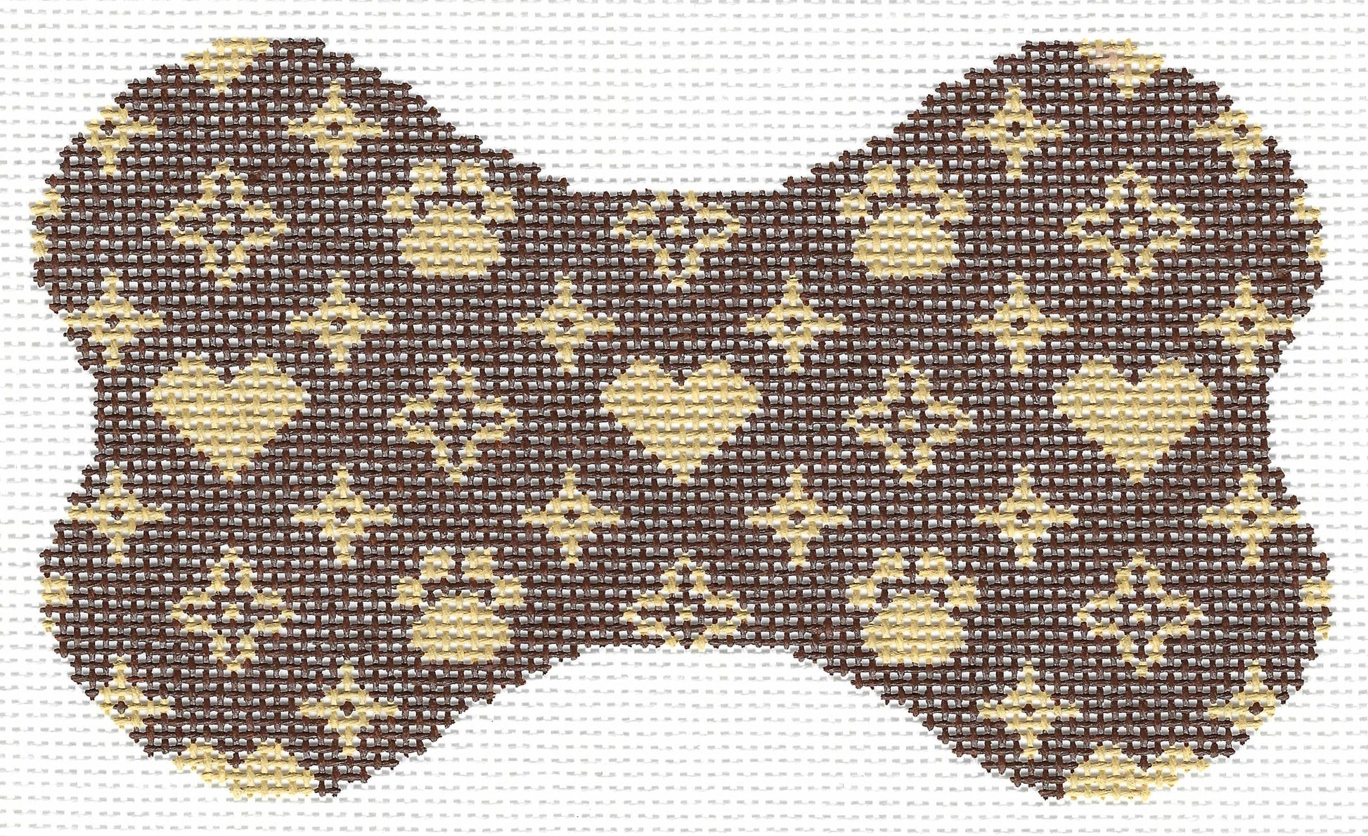 Lauren Bloch Designs bone-shaped needlepoint canvas with a repeating  pattern of beige hearts, paw prints, and diamond motifs on a dark brown background.