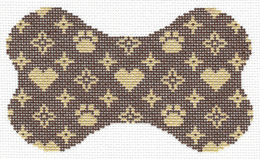 Lauren Bloch Designs bone-shaped needlepoint canvas with a repeating  pattern of beige hearts, paw prints, and diamond motifs on a dark brown background.