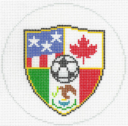 Needlepaint needlepoint canvas of a shield-shaped design featuring the United States flag, the Canadian flag, a soccer ball, and the Mexican flag on a white background.