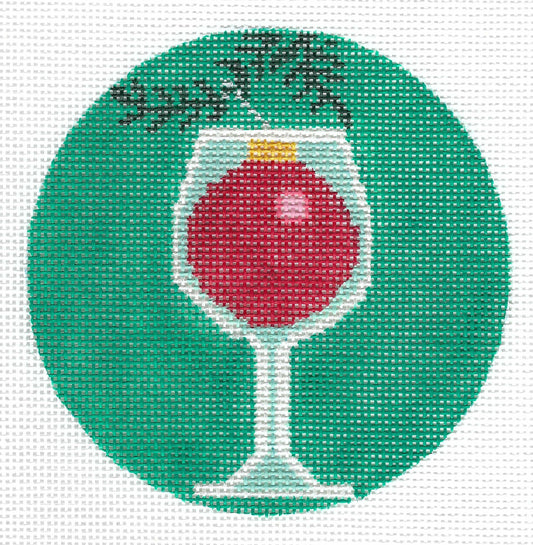 3 Kittens circular needlepoint canvas design featuring a green background with a wine glass containing red tree ornament hanging from a branch.