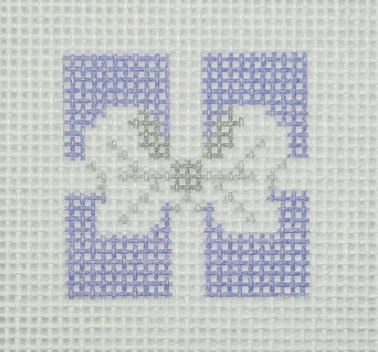 Tilli Tomas Planet Earth needlepoint canvas of top of purple gift with a silver bow