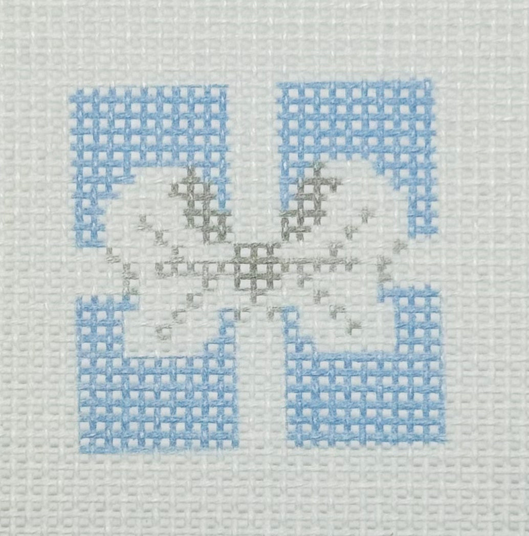 Tilli Tomas Planet Earth needlepoint canvas of top of light blue gift with a silver bow