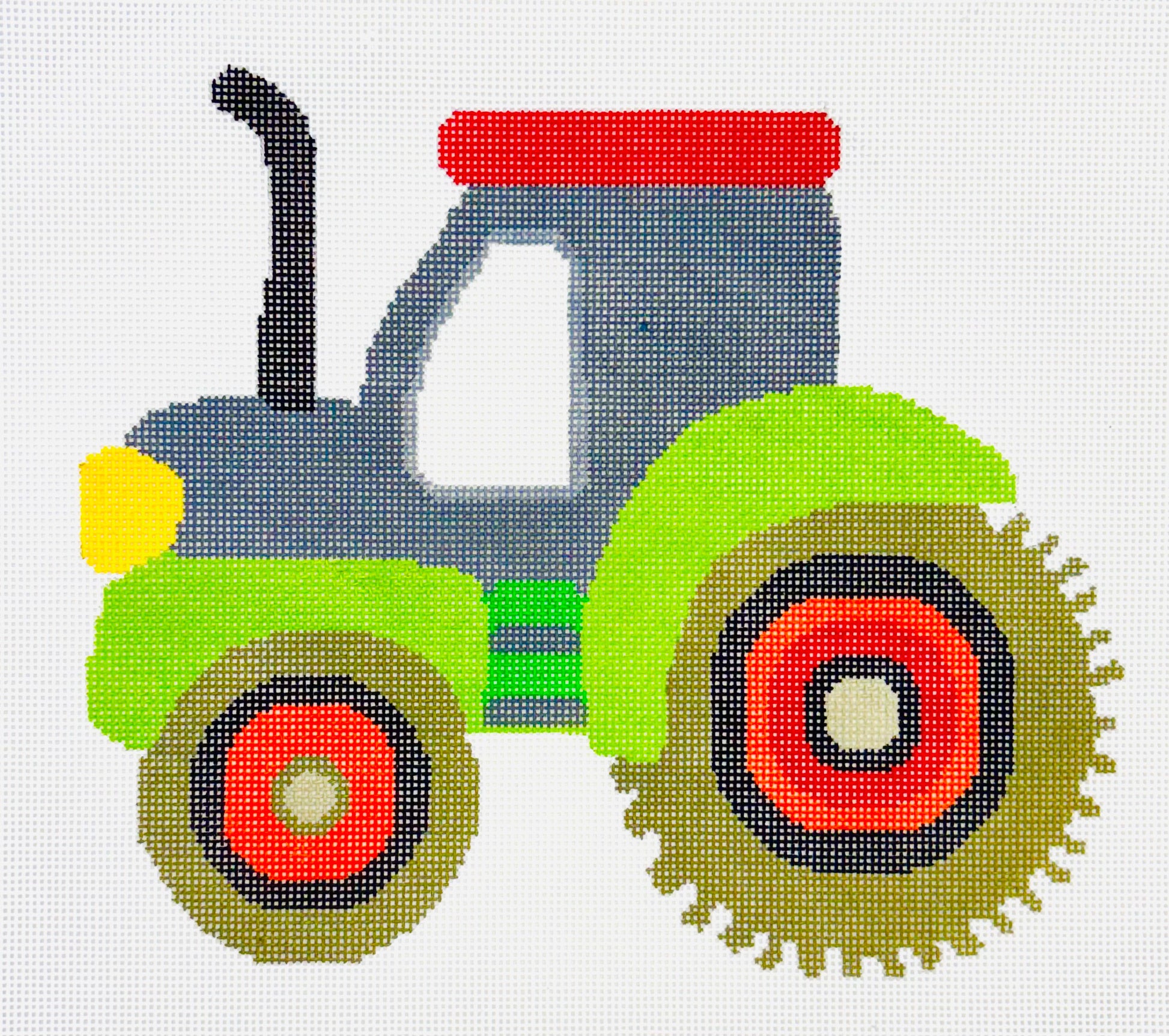 A Stitch in Time needlepoint canvas of a colorful green and red tractor design on a white background