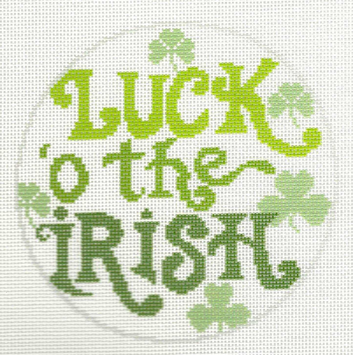 Needlepaint round needlepoint canvas with 'Luck o' the Irish' text and shamrocks on a white background