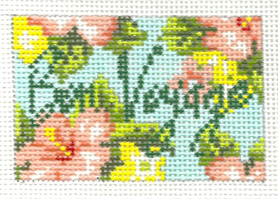 Kirk & Bradley luggage tag needlepoint canvas of floral pattern with pink, yellow, and green on a light blue background with text 'Bon Voyage'