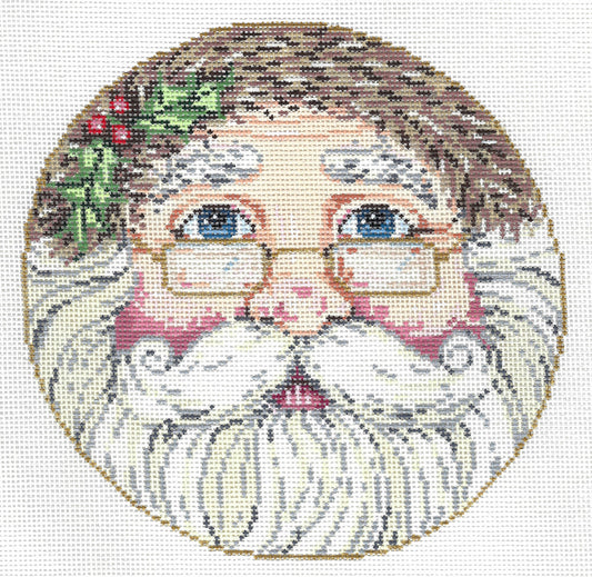 Sandra Gilmore circular needlepoint canvas featuring a design of Santa Claus's face, with brown hair, blue eyes, gold-rimmed glasses, a white beard, and a small green holly sprig on the left side.