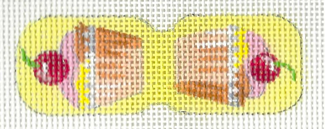Kirk & Bradley needlepoint canvas of a scissor finder with a cherry cupcake on each side and a yellow background