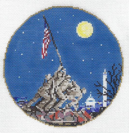 Sandra Gilmore circular needlepoint canvas featuring a patriotic scene with the US flag raised over a mountain, a bright full moon, stars, and a white dome building under a deep blue night sky.