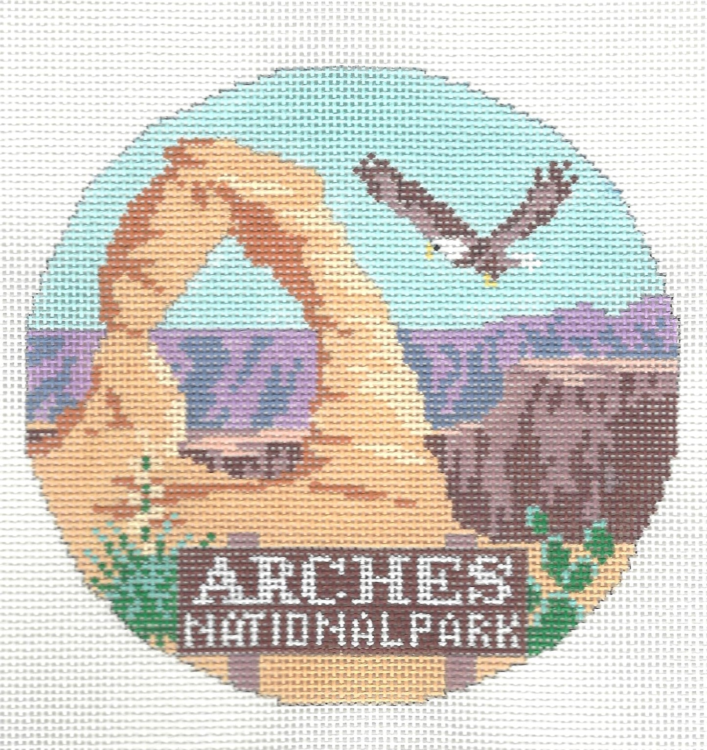 Kirk & Bradley round needlepoint or cross-stitch design of Arches National Park with a natural landscape and eagle.