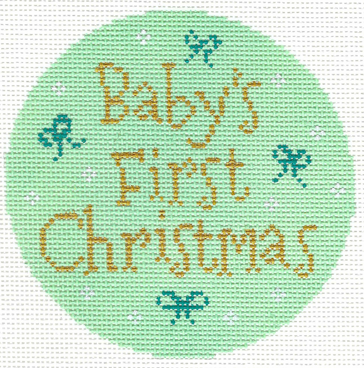 Stitch Rock circular needlepoint canvas featuring the text 'Baby's First Christmas' in gold lettering on a light mint green background, decorated with small teal bows and white snowflakes.
