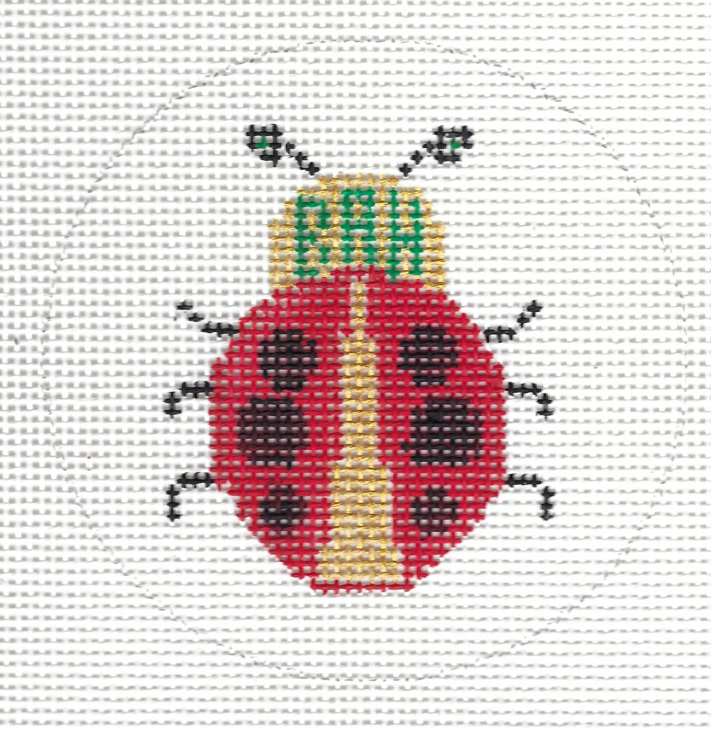 Patricia Stone round needlepoint canvas of a ladybug design with a red body, black spots and legs, a yellow belly, and green embroidered letters reading 'BAH' on the head.