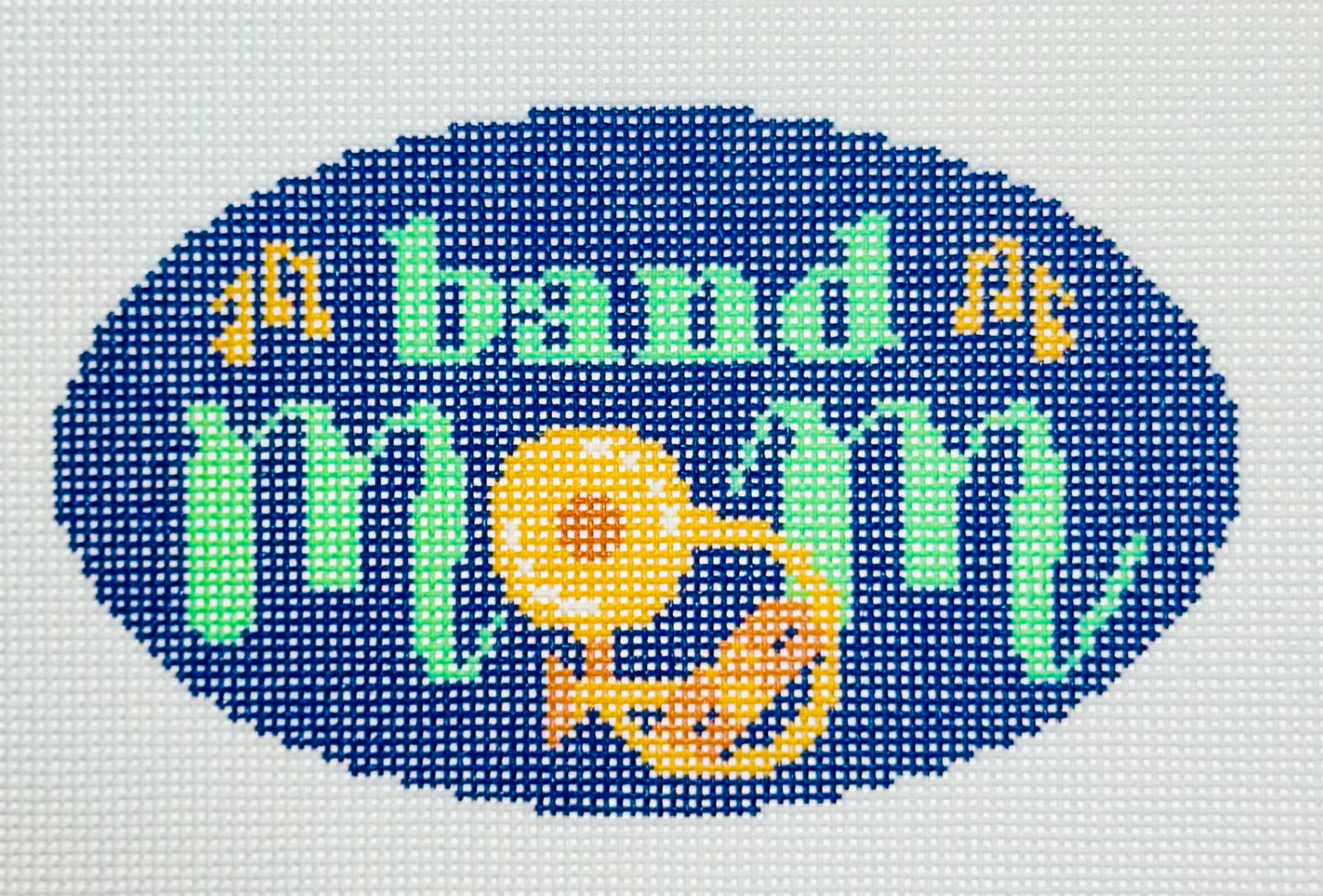 KCN Designers needlepoint canvas of 'Band Mom' with a brass instrument for the 'O' in 'mom' on a dark blue background.