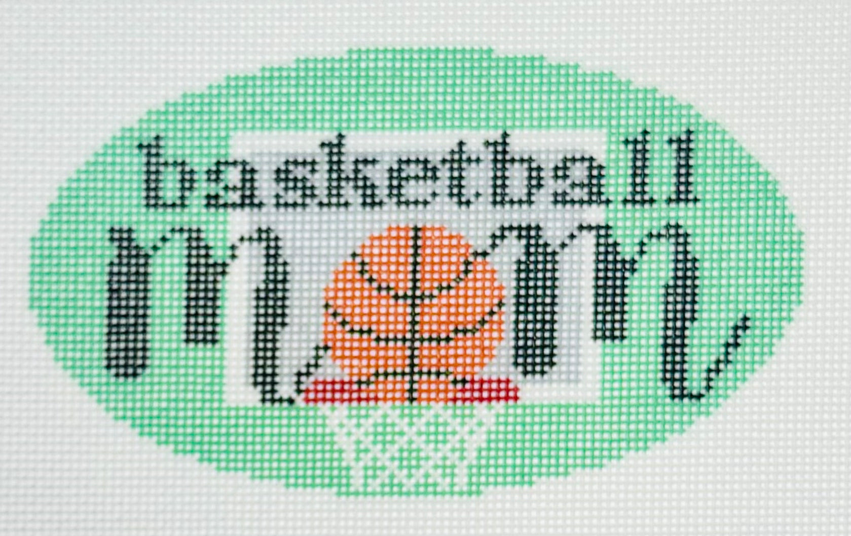 KCN Designers needlepoint canvas of 'Basketball Mom' with a basketball for the 'O' in 'mom' on a light green background.
