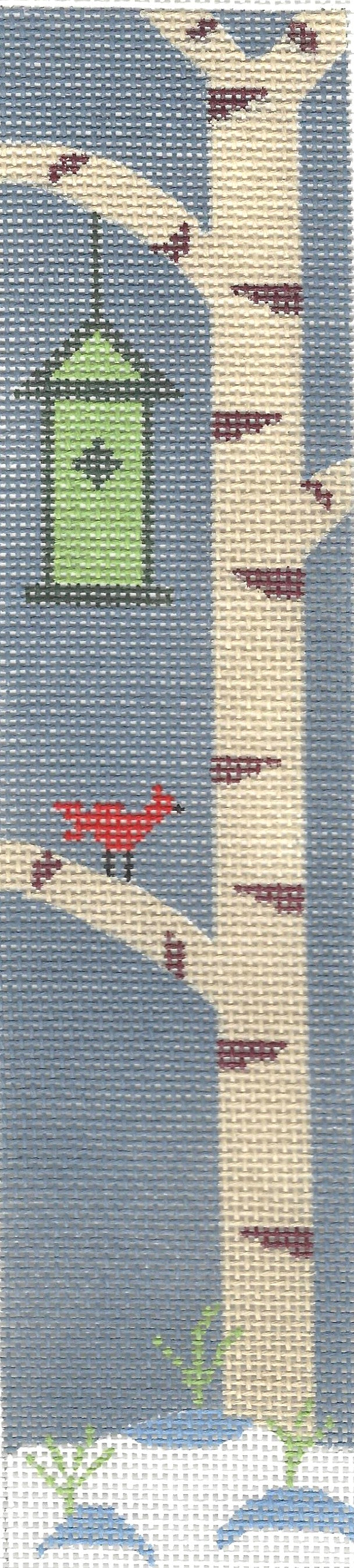 j. childs needlepoint canvas of a red bird on a branch with a green birdhouse with snow on the ground and a dark blue/gray background