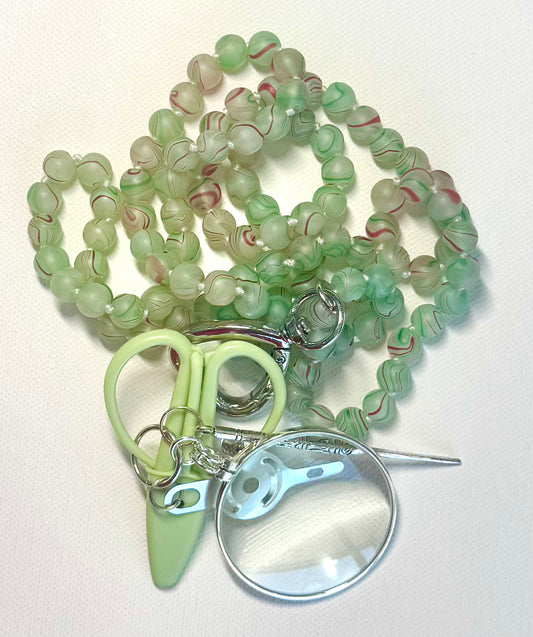 Victoria Whitson chatelaine with gemstone matte key lime swirl beads with mini scissors, a magnifying glass, and accessories.