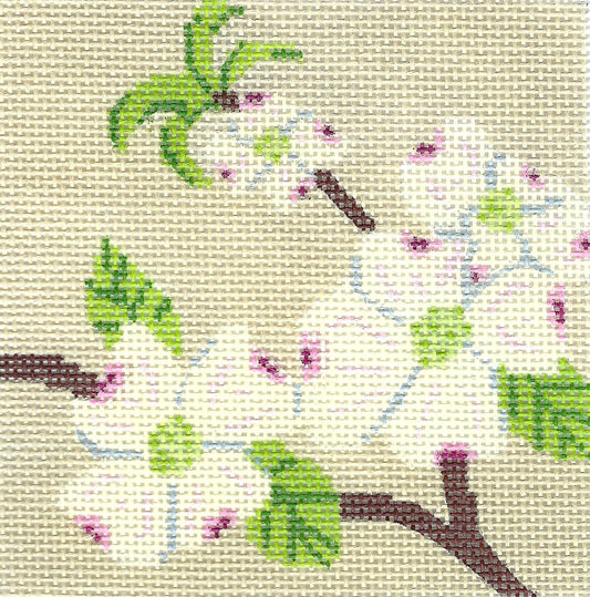 j. childs needlepoint coaster canvas featuring white blossoms, green leaves, and brown branches on a beige grid canvas.
