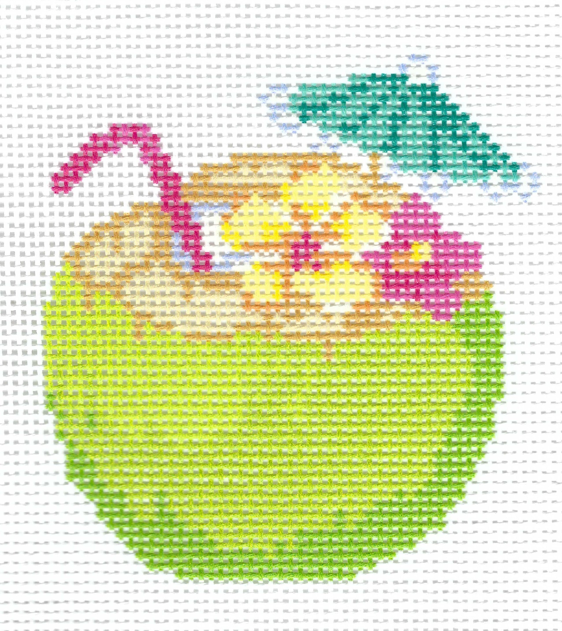Needlepoint canvas of illustration of a green coconut with a red straw, a green umbrella, and pink and yellow flowers on a white grid background.