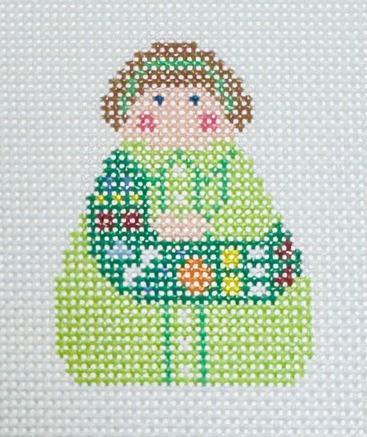 KCN Designers needlepoint canvas of a Georgette's Angel of a girl scout with a light green uniform and dark green sash with badges.
