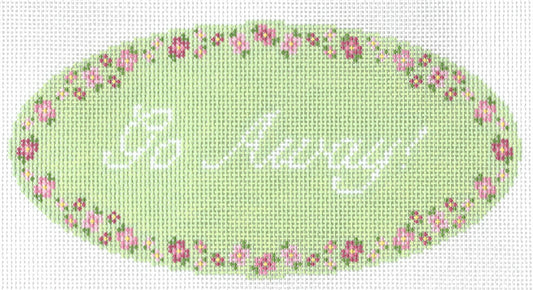 Maura Nolan needlepoint canvas of text 'Go Away!' on a green oval background with a floral border.