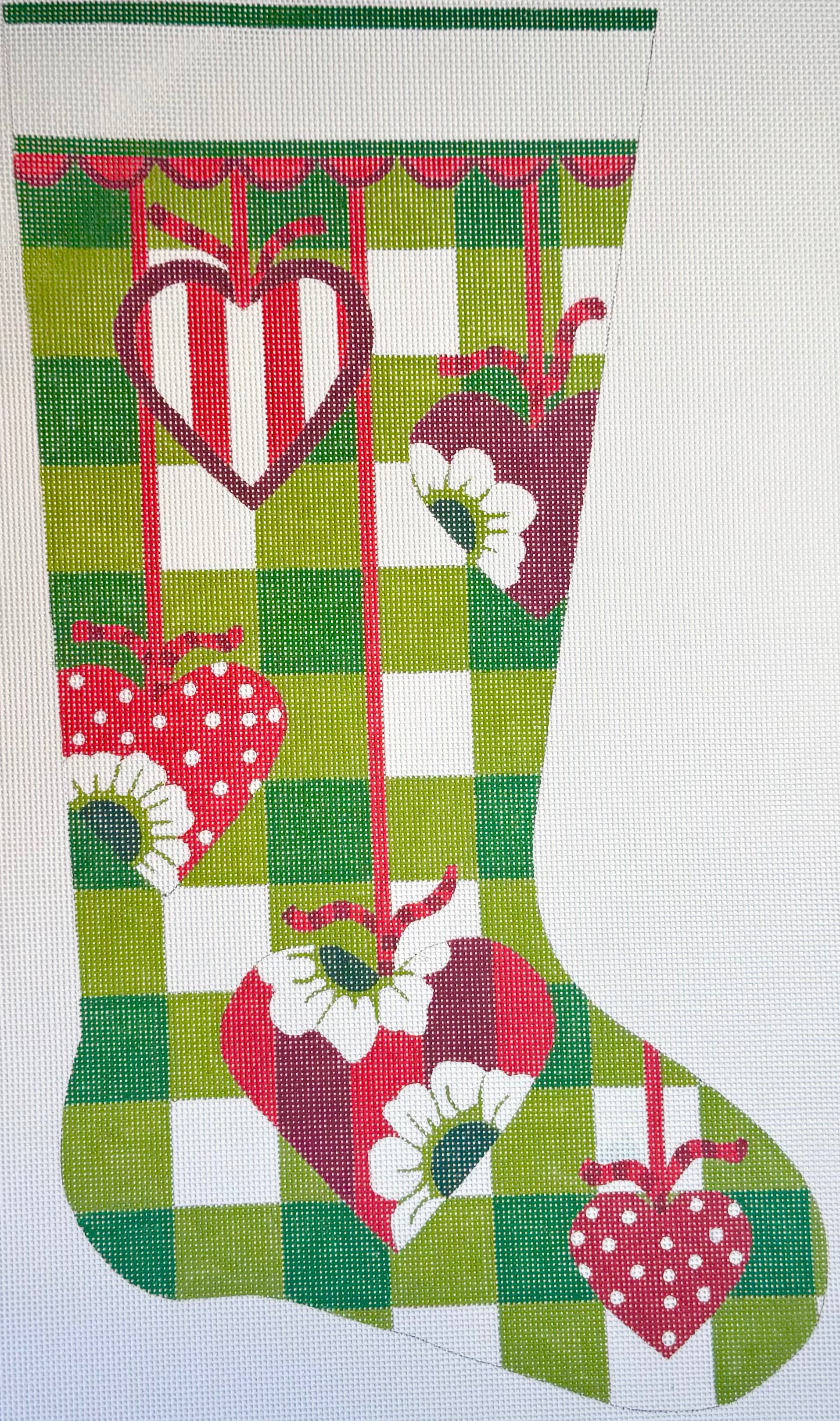 Alice Peterson Co. needlepoint canvas of Christmas stocking with hearts and floral patterns with a green and white checkered background.