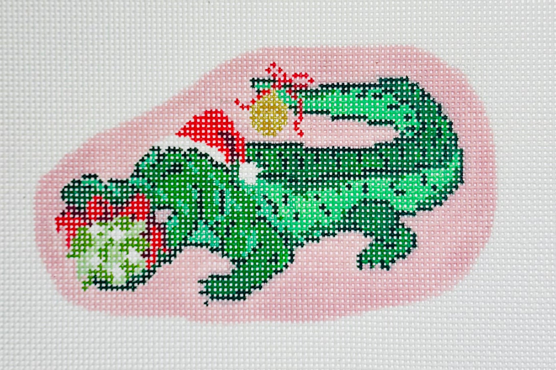 KCN Designers needlepoint canvas of a green holiday alligator with Santa hat and ornaments