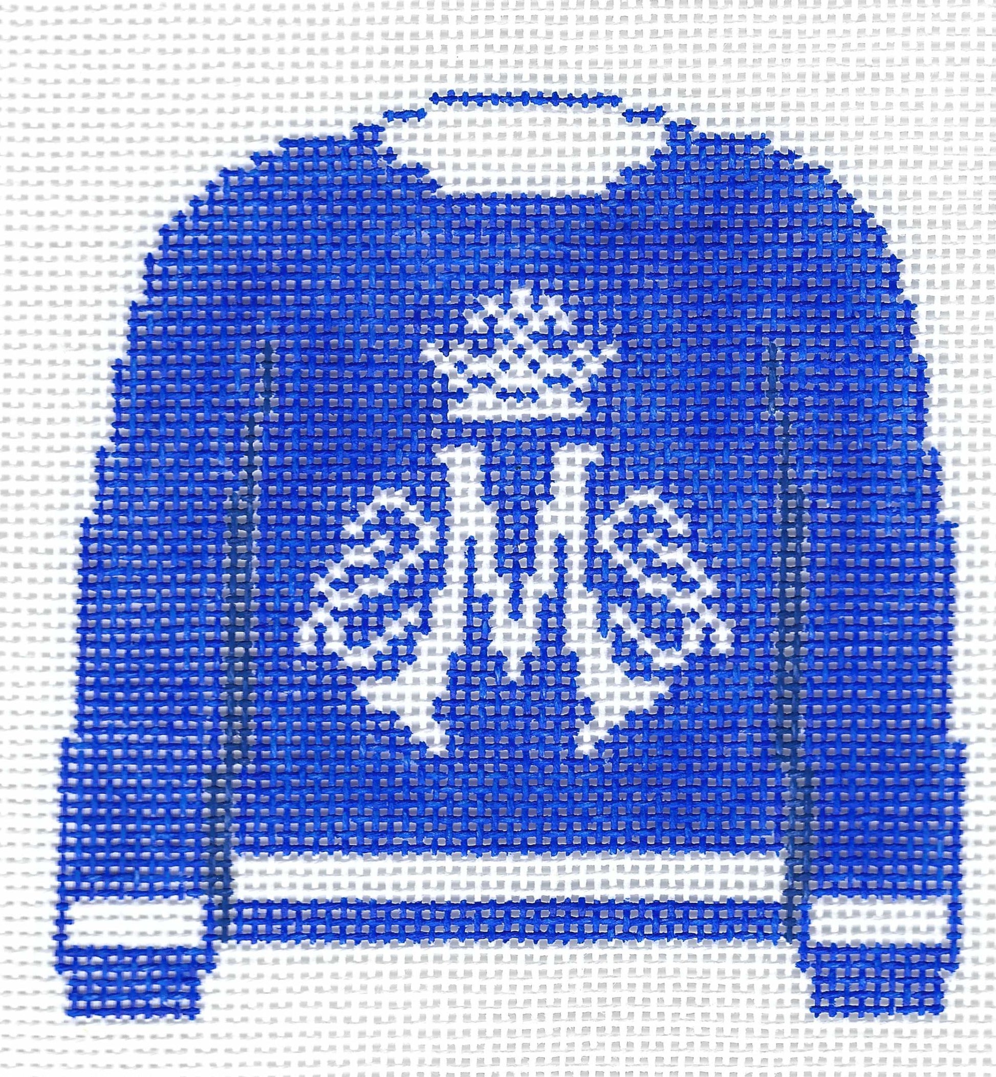 Needlepoint canvas of a blue pullover sweater with white Marian logo on a white background.