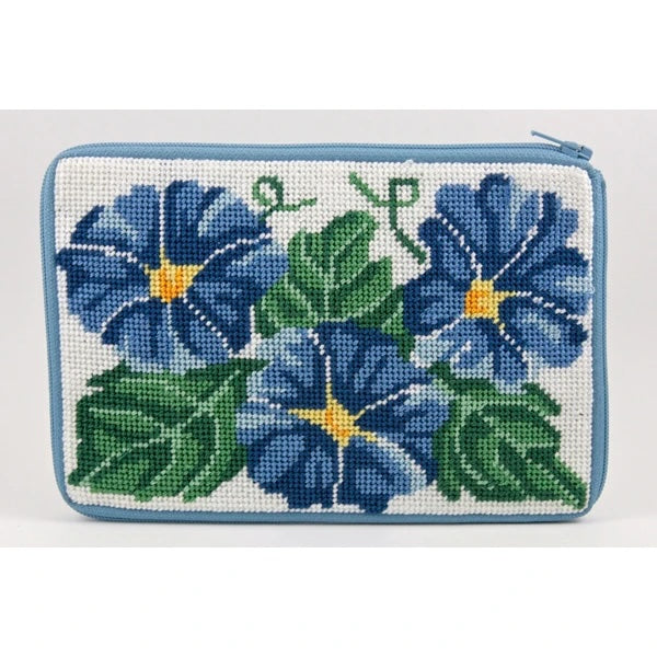 Stitch & Zip cosmetic purse DIY needlepoint kit featuring a floral design of blue flowers and green leaves on a white background, finished with a light blue stitched border.