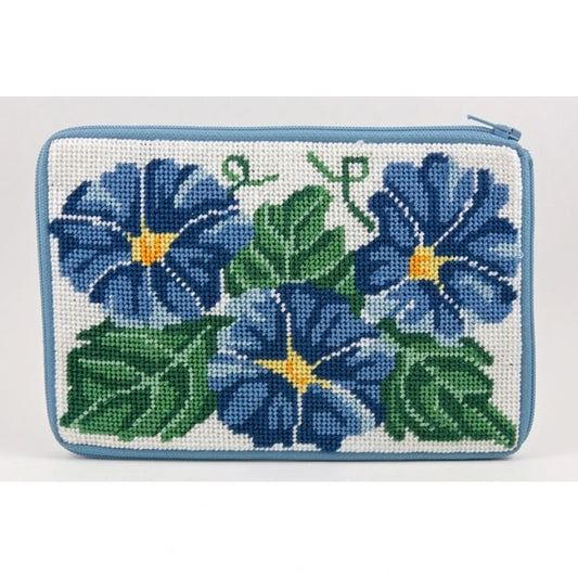 Stitch & Zip cosmetic purse DIY needlepoint kit featuring a floral design of blue flowers and green leaves on a white background, finished with a light blue stitched border.