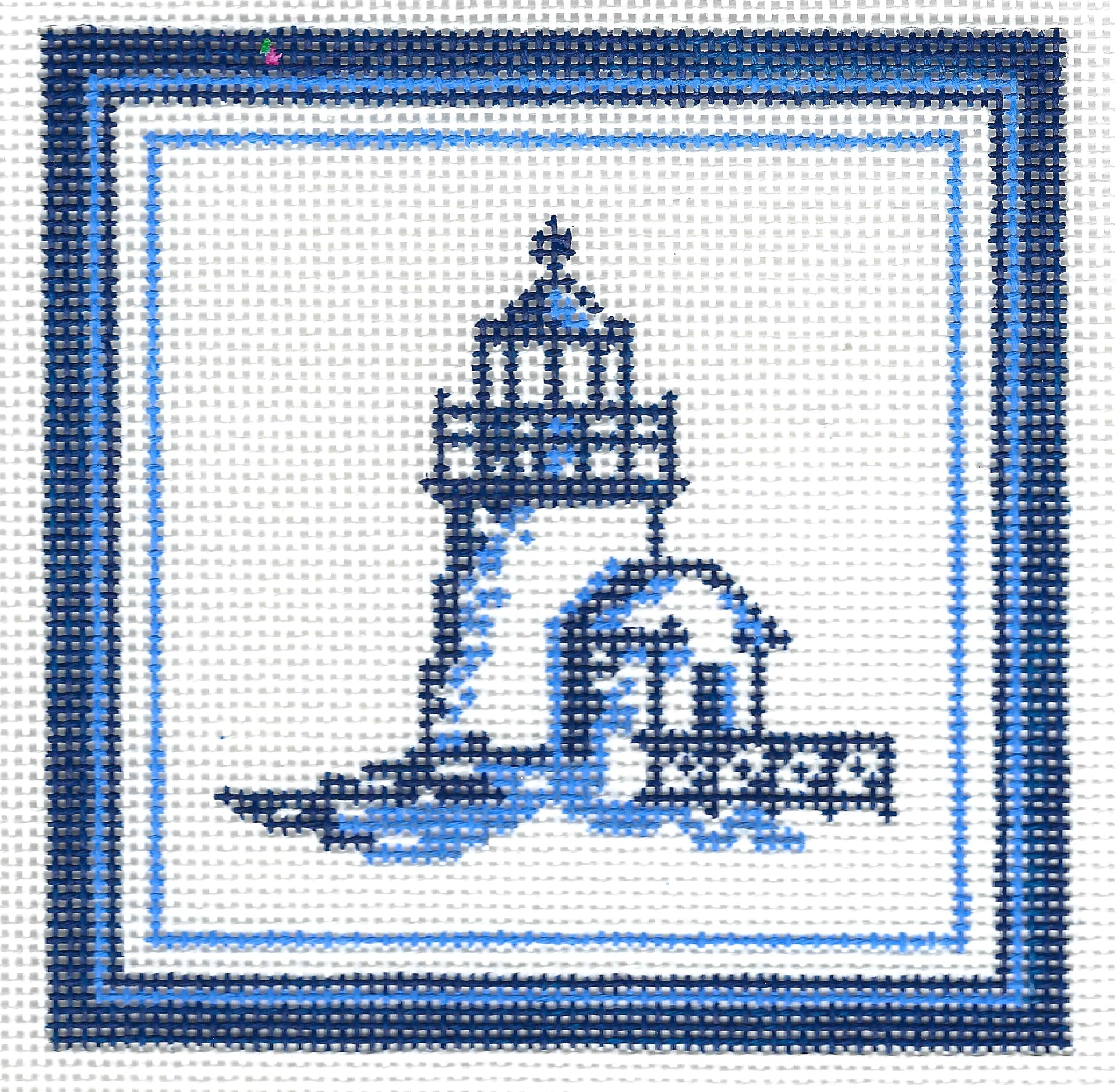 Kirk & Bradley square needlepoint canvas featuring a blue and white lighthouse and small house design, bordered by concentric blue and white frames on a white background.