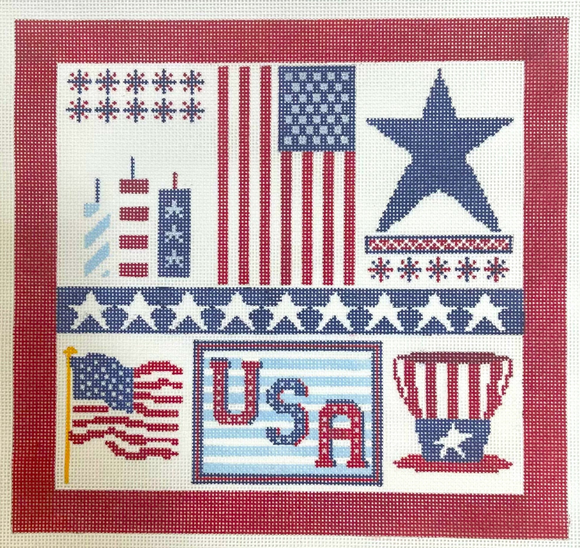 A Stitch In Time needlepoint canvas of collage with American flags, stars, and 'USA' text with a red border.