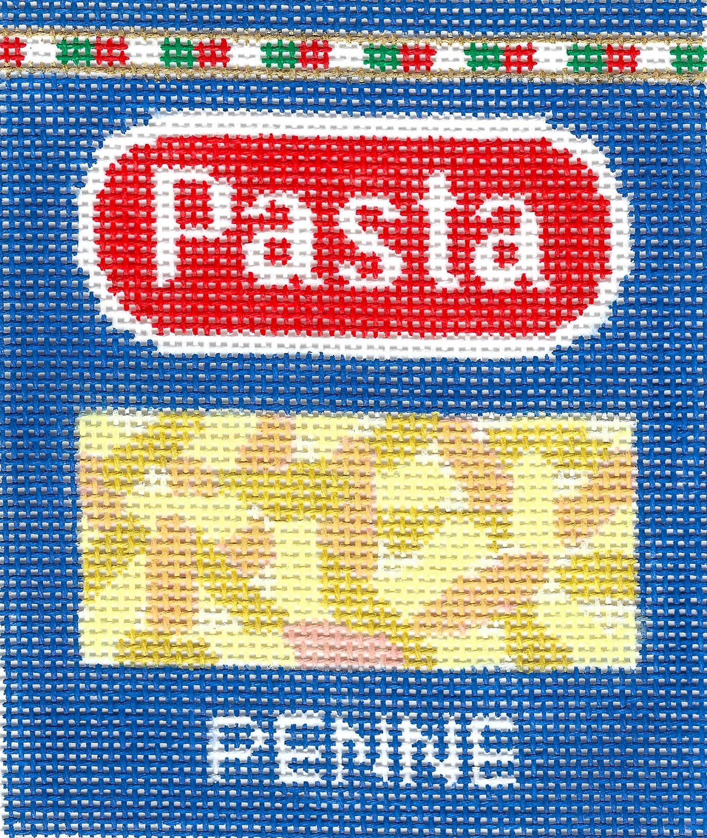Stitch Rock needlepoint canvas of a blue pasta package label with a red oval containing the word 'Pasta' in white, a yellow rectangular product area that shows the noodles in the box, and the word 'PENNE' in white at the bottom.