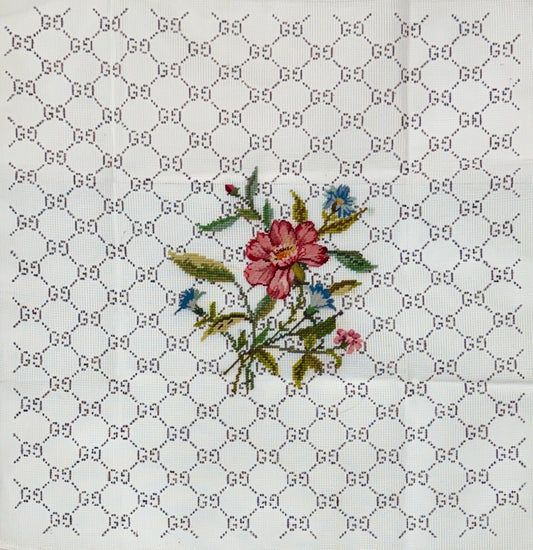 Jessica Tongel Designs needlepoint canvas featuring a repeating interlocking G pattern, with a central embroidered floral motif in pink, green, and blue.