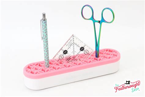 Yarn Tree pink and white sewing kit with scissors, pen, and a ruler on a white background.