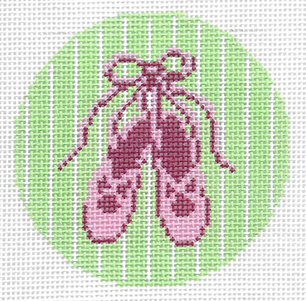 Lee's Needle Art round needlepoint canvas of pink ballet slippers on a green and white striped background.