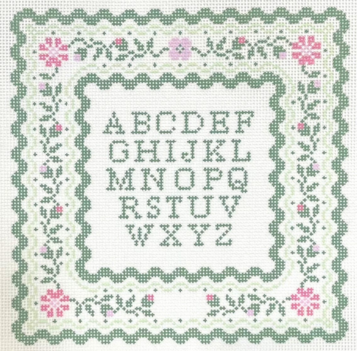 Maura Nolan needlepoint canvas of alphabet pattern with decorative border on a white background
