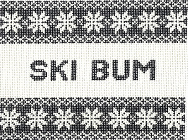 Saturnalia Stitching needlepoint canvas of a knitted textile pattern with black and white Nordic snowflake motifs and the words 'SKI BUM' centered on a white band.
