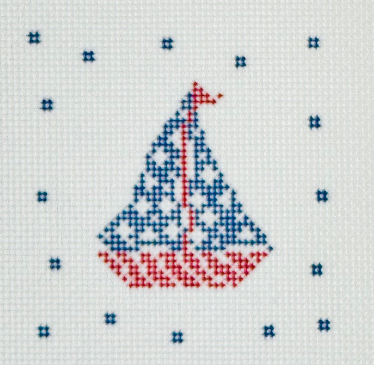 KCN Designers needlepoint canvas of a patriotic sailboat with a blue sails with white stars and a red and white striped boat.