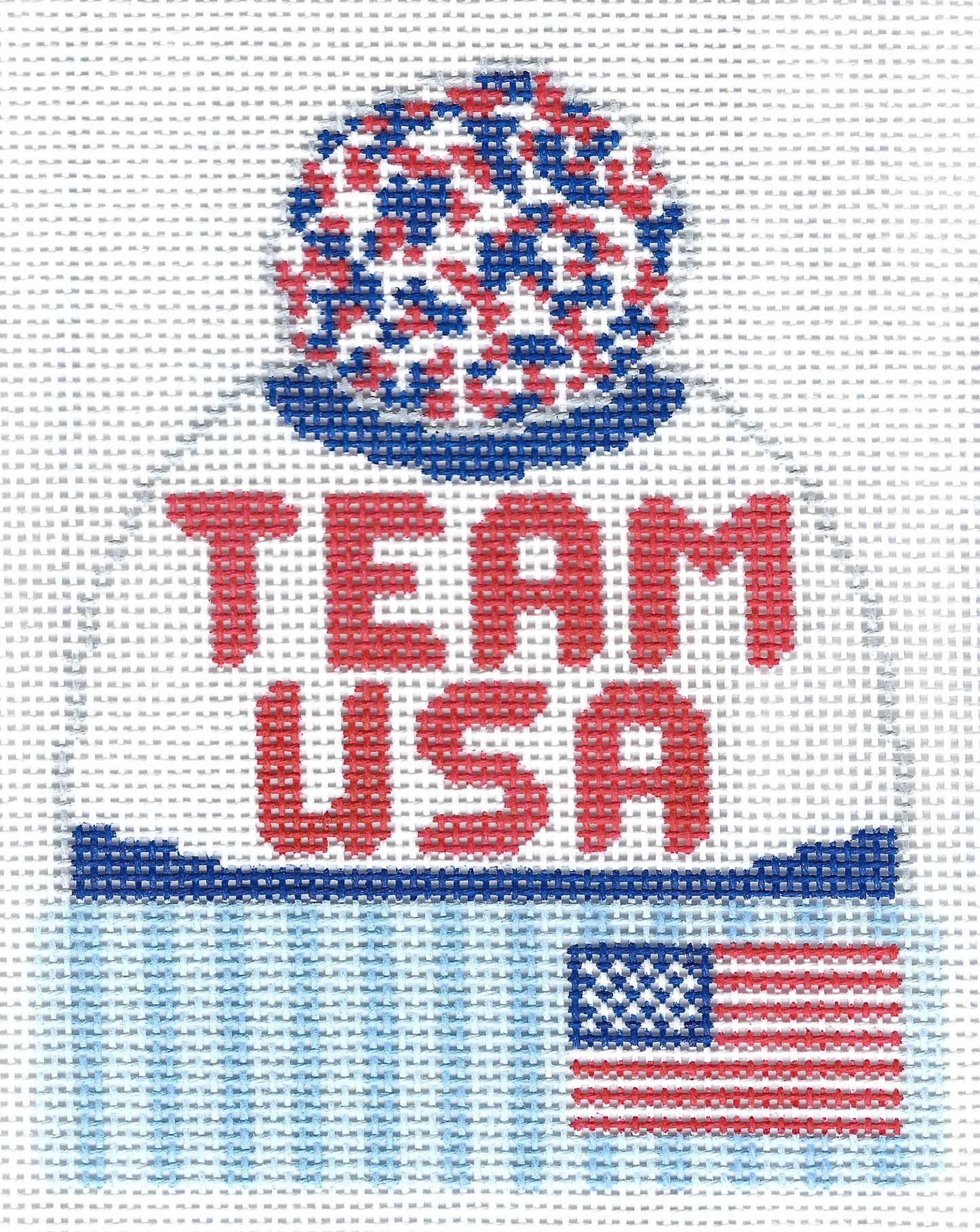 Lauren Bloch Designs needlepoint canvas of a beanie with 'Team USA' text, an American flag, and a red/white/blue pom pom on top.